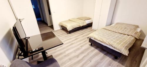 Cette chambre comprend 2 lits, une table et un miroir. dans l'établissement Apartments EFDE GmbH Ferienwohnung, à Heilbronn