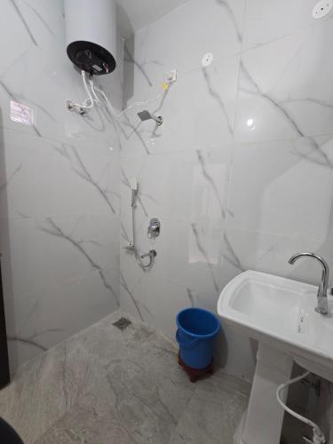 a white bathroom with a shower and a sink at Corridor inn in Derā Nānak