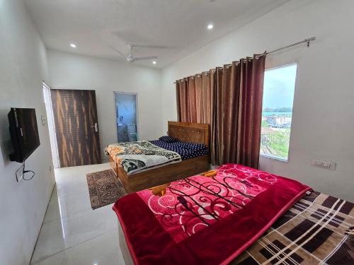 1 dormitorio con 2 camas y TV. en Corridor inn, en Derā Nānak