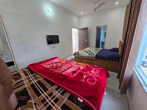 a bedroom with a bed with a red blanket on the floor at Corridor inn in Derā Nānak