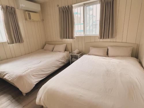 two beds in a room with two windows at ライフタイムハウス55 in Furugen