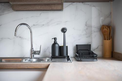 a kitchen counter top with a sink and a sink at Caramel by OneApartments in Sopot