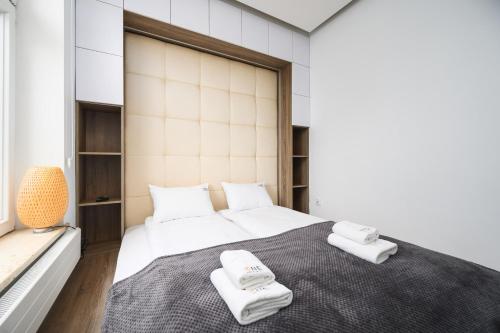 een slaapkamer met een groot bed en handdoeken bij Caramel by OneApartments in Sopot