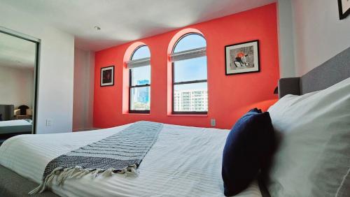 a bedroom with red walls and windows and a bed at The Lofts on Clematis 502 Downtown West Palm Beach in West Palm Beach
