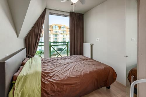 ein Schlafzimmer mit einem Bett und einem großen Fenster in der Unterkunft Triniteyt 0302 P7 in Nieuwpoort