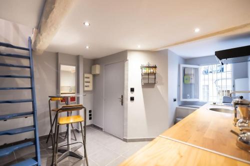 une cuisine avec un comptoir et un tabouret dans une pièce dans l'établissement Le Coloré, Beau T2, Centre Historique, à Montpellier