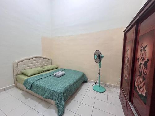 ein Schlafzimmer mit einem Bett und einem Ventilator in der Unterkunft Singgah Manis Homestay Keningau in Keningau