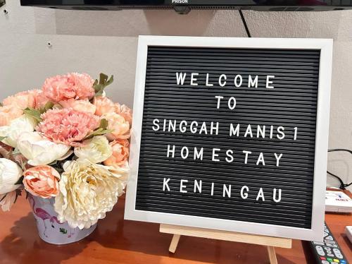 Ein Zeichen, das sagt, willkommen bei Singaugh mans Homiversary neben Blumen. in der Unterkunft Singgah Manis Homestay Keningau in Keningau