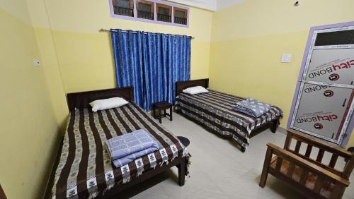 a room with two beds in a room at Balaji Homestay in Guwahati