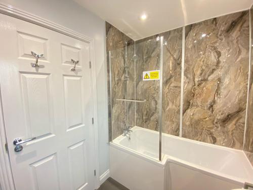 a bathroom with a shower and a tub and a sink at Arthur's Retreat in Filey