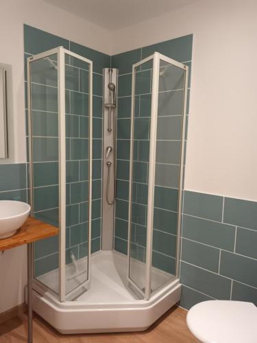 La salle de bains est pourvue d'une douche et de carrelage vert. dans l'établissement La Yourte de la Mariotte, à Montredon