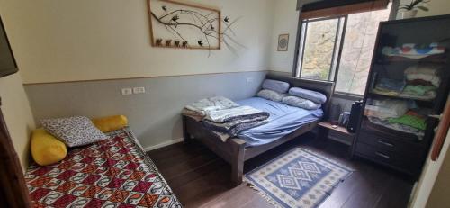 Cette petite chambre comprend un lit et une fenêtre. dans l'établissement אור בתבור, אירוח בכפר תבור., à Kefar Tavor