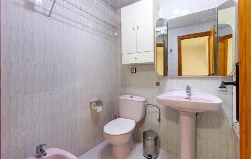 een badkamer met een toilet, een wastafel en een spiegel bij Cozy Home In Gran Alacant With Outdoor Swimming Pool in Gran Alacant