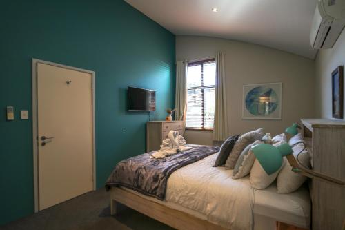 um quarto com paredes verdes e uma cama com animais de peluche em Retreat on Fearn em Margaret River Town