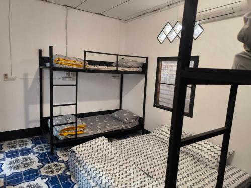 a room with two bunk beds in a room at บ้านพักเหมาหลังเชียงคาน ฮักเลย ฮักกัญ โฮมสเตย์ 2- ຊຽງຄານ ຮັກເລີຍ ຮັກກັນ ໂຮມສະເຕ2 -Chiang Khan Hugloei HugKan Homestay2 in Chiang Khan