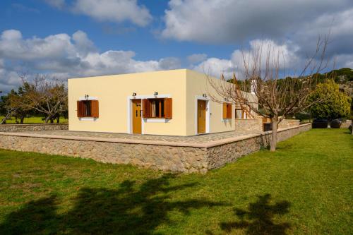 una piccola casa con un muro di pietra di Hermes' Getaway Plimmiri a Plimmiri