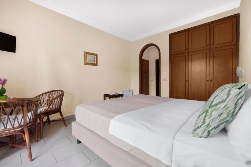 a bedroom with a bed and a table and a chair at Hotel Desiree in Sorrento