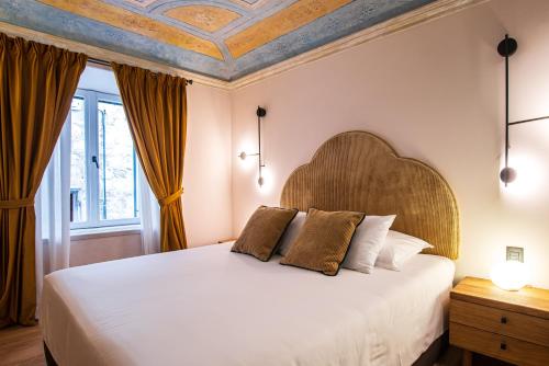 Schlafzimmer mit einem weißen Bett mit einem Kopfteil aus Holz in der Unterkunft 7oaks Noble House in Dubrovnik