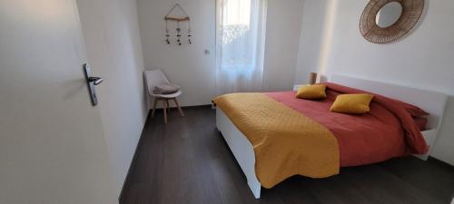 a bedroom with a bed with yellow and red sheets at Appartement Port-Mer près des plages in Cancale