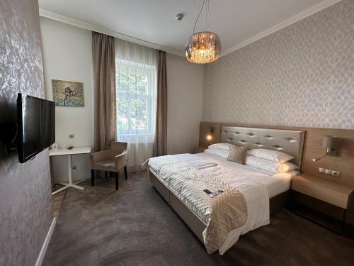 a bedroom with a bed and a desk and a television at Mamaison Residence Sulekova Bratislava in Bratislava
