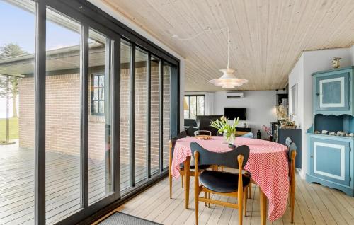a dining room with a table and some windows at Awesome Home In Roslev With Kitchen in Roslev
