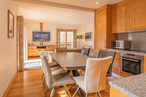 une cuisine et une salle à manger avec une table et des chaises dans l'établissement Grand Paradis- Modern 3 bedroom apartment with spectacular views, à Chamonix-Mont-Blanc
