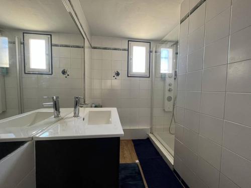 une salle de bain blanche avec un lavabo et une douche dans l'établissement Maison Climatisée à 2 Pas de la Plage avec Piscine et Parking Privé, 6 Couchages - Gruissan - FR-1-229-486, à Gruissan