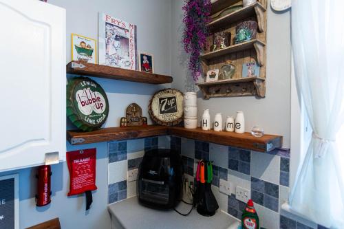 a corner of a kitchen with a shelf and a sink at Apartment with Free parking - 6 min drive to beach! in Southend-on-Sea