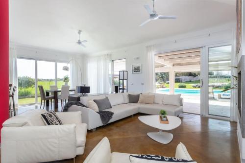 a living room with a white couch and a table at [Villa Fenice] Swimming Pool, big garden & Gym in Nurachi