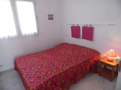 - une chambre avec un lit rouge et une couverture rouge dans l'établissement Appartement T2 cabine avec terrasse, proche plage, parking privé, pour 4 personnes. - FR-1-326-547, à Le Castellas