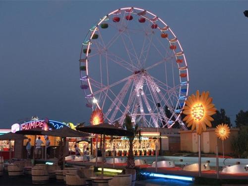 une grande roue dans un parc d'attractions la nuit dans l'établissement Appartement T2 cabine avec terrasse, proche plage, parking privé, pour 4 personnes. - FR-1-326-547, à Le Castellas
