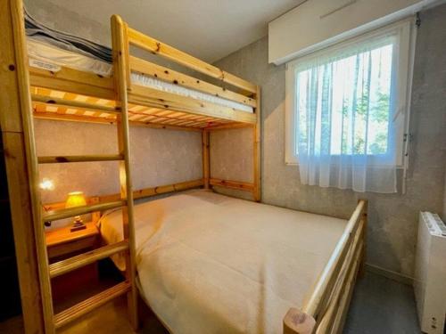 une chambre avec deux lits superposés et une fenêtre dans l'établissement Quiberon : 3 pièces, 5 pers, piscine, près plage, garage, animaux ok, terrasse/jardin - FR-1-478-85, à Quiberon
