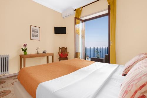 a bedroom with a bed and a large window at Hotel Desiree in Sorrento