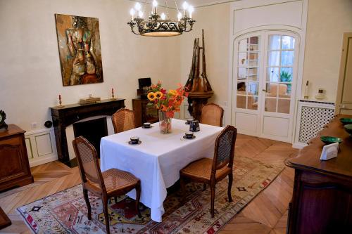comedor con mesa y chimenea en CHAMBRES D'HÖTES DANS MAISON DE MAÏTRE DU XVIIIe SIECLE, en Houdan