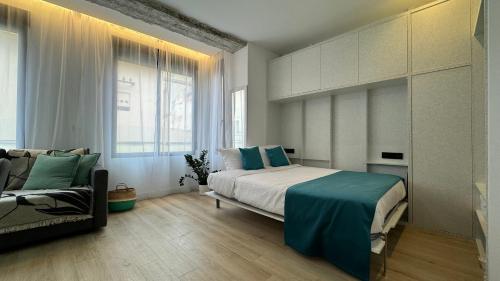 a bedroom with a large bed and a couch at Apart-hotel Happy Life in Alicante