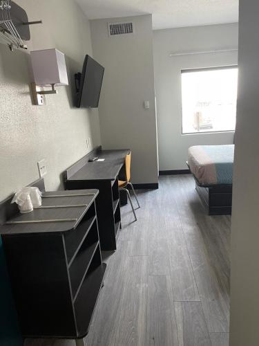 a hotel room with a bed and a desk and a room with a sink at Motel 6-Caseyville, IL - Caseyville Il in Caseyville