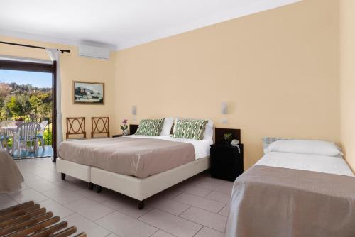 a bedroom with two beds and a balcony at Hotel Desiree in Sorrento