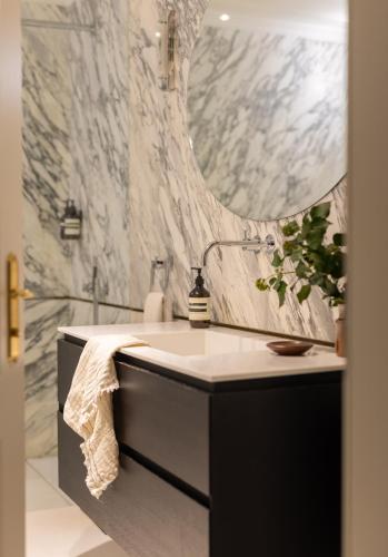 a bathroom with a sink and a mirror at The Hamlet - Luxury Serviced Apartments in Geneva