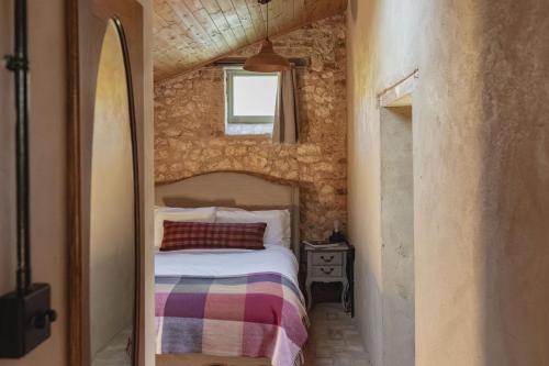 een kleine slaapkamer met een bed in een bakstenen muur bij The Little Potting Shed in Sedgeford
