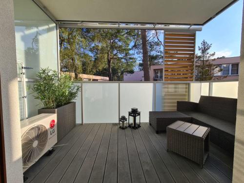 eine Außenterrasse mit einem Sofa und einem Ventilator in der Unterkunft Nautikka Park Krynica Apartamenty Przy Plaży in Krynica Morska