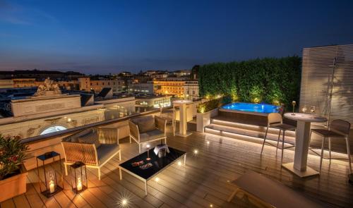 a rooftop deck with a view of a city at night at The Glam in Rome