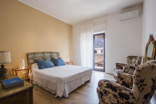 - une chambre avec un lit, deux chaises et une fenêtre dans l'établissement Zafferana Apartment with Balcony by Wonderful Italy, à Zafferana Etnea