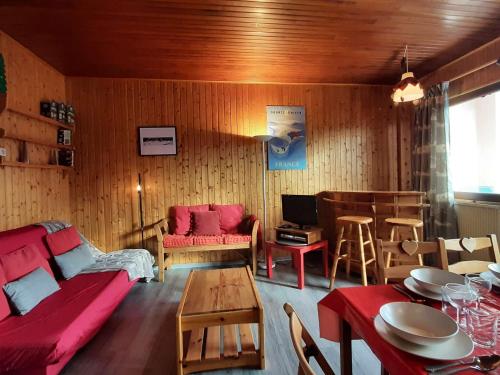 un salon avec un canapé rouge et une table dans l'établissement Appartement 3 pièces pour 6 au ski avec parking à Montgenèvre - FR-1-330D-13, à Montgenèvre