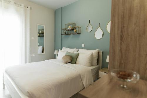 a bedroom with a white bed and a table at Magico Home City Heart Luxury Appartment in Alexandroupoli