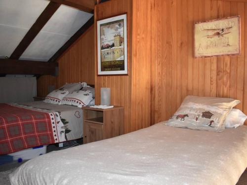 two beds in a room with wooden walls at Appartement Font-Romeu-Odeillo-Via, 2 pièces, 7 personnes - FR-1-580-27 in Font-Romeu-Odeillo-Via