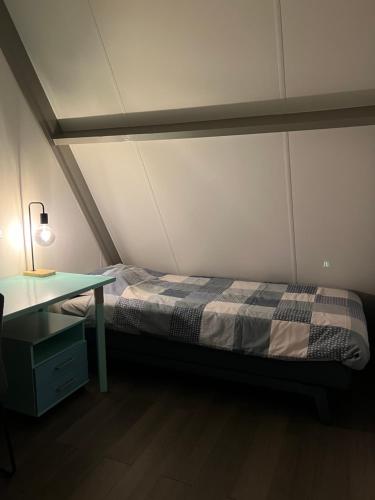 Ce lit se trouve dans un dortoir doté d'un bureau et d'un lit sidx sidx. dans l'établissement Dennenrust A-frame huisje middenin het bos., à Lanaken