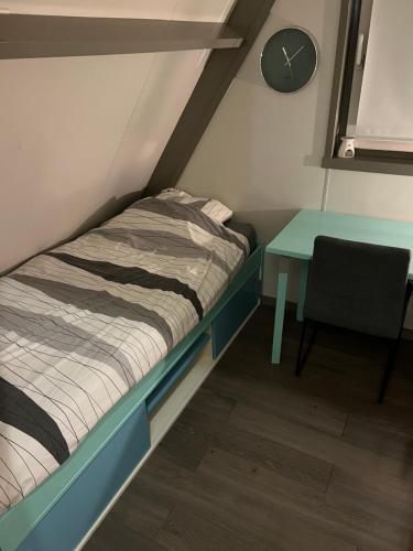 - un petit lit et une table dans une chambre dans l'établissement Dennenrust A-frame huisje middenin het bos., à Lanaken