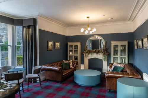 a living room with leather furniture and a fireplace at Udny Arms Hotel in Newburgh