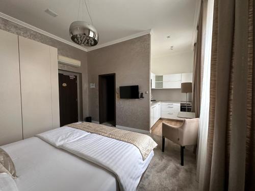 a bedroom with a bed and a desk and a television at Mamaison Residence Sulekova Bratislava in Bratislava