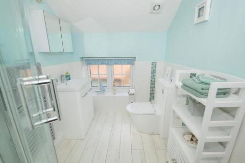 a white bathroom with a toilet and a sink at 5* Family Holiday Home in the Yorkshire Wolds in Huggate